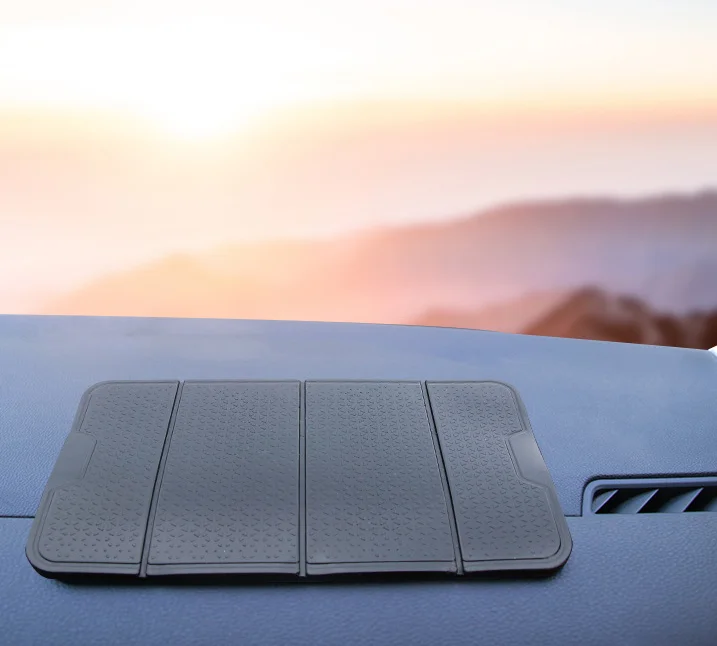 Anti-Slip Mobile Phone Stand and Holder on a dashboard during sunset.