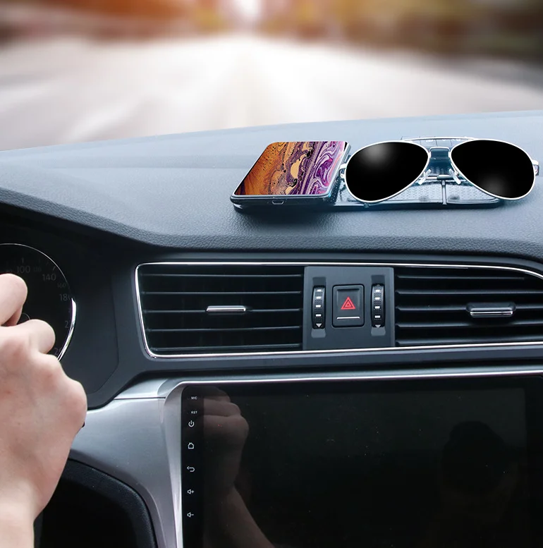 Anti-Slip Mobile Phone Stand and Holder holding a phone on a car dashboard with sunglasses.